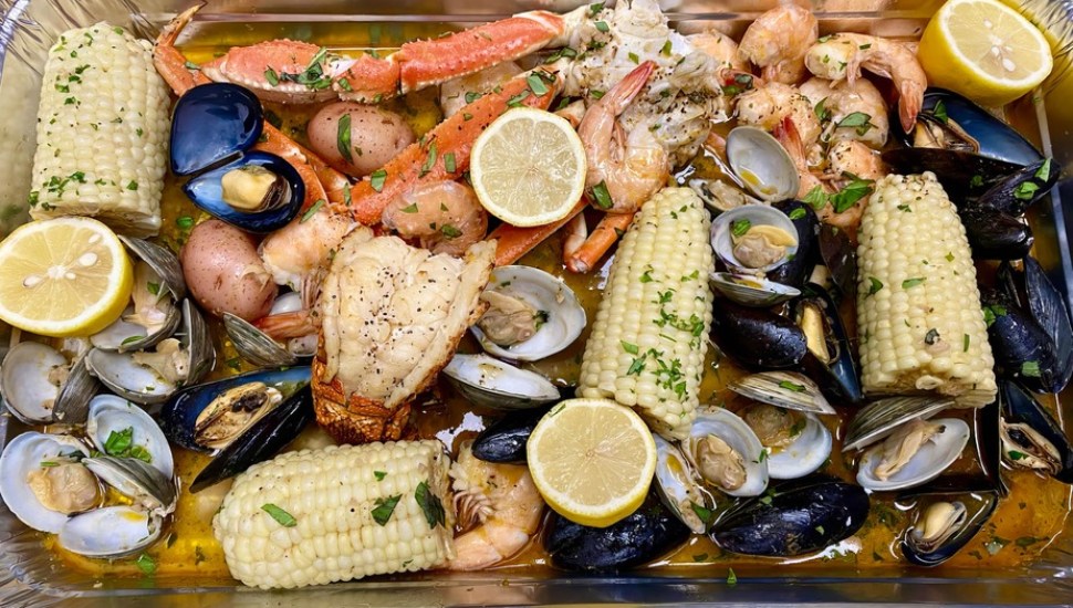 Lobster tail, shrimp, crab leg, mussels, clams, corn, and potatoes.