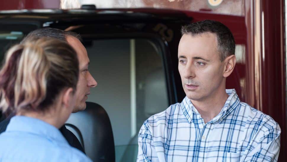 Brian Fitzpatrick speaking with two people.