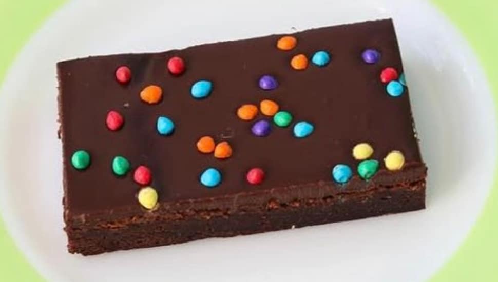 A brownie with colorful candy sprinkles on a plate.