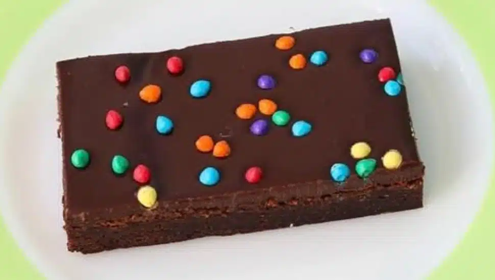A brownie with colorful candy sprinkles on a plate.