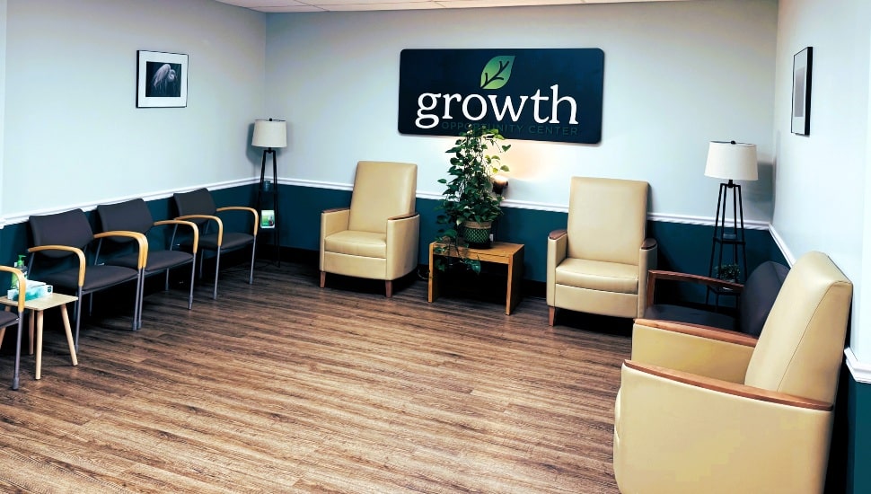 Doctor's office lobby with wooden floor and brown chairs.