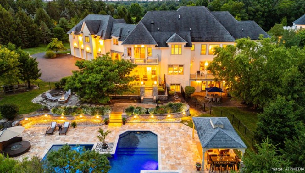 Aerial shot of Newtown mansion with a large outdoor area featuring a cabana and pool.