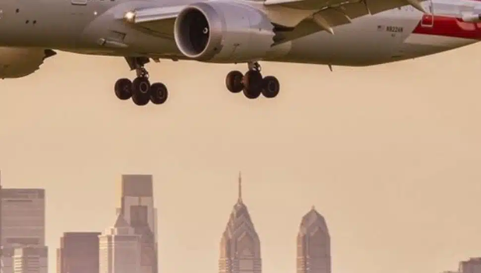 An American Airlines jet approaches landing with the skyline of Philadelphia in the background.