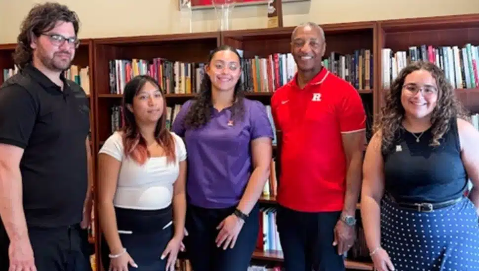 College president poses for a group picture with students.