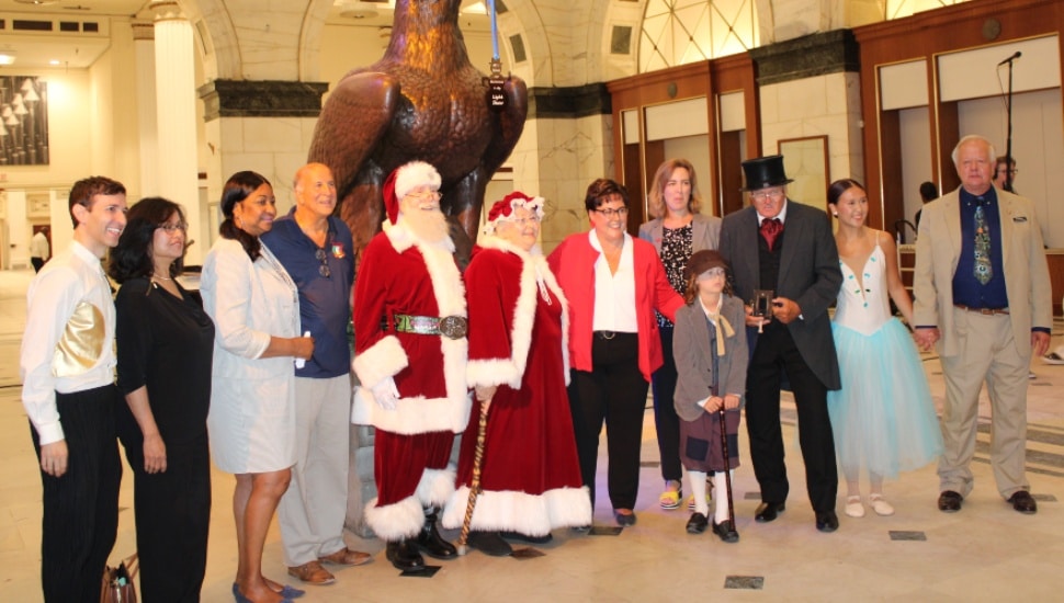 City officials and leaders pose in front of the Eagle inside the Wanamaker Building.