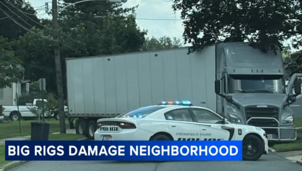 A police car contains a big rig truck that cause damage navigating streets in a Prospect Park neighborhood.