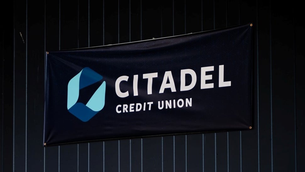 Banner with bank signage hangs on curtain.
