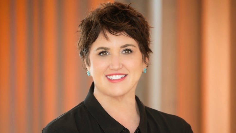 Headshot of middle-aged woman with short dark hair and dark suit jacket.