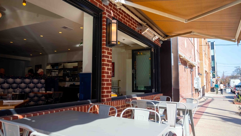Large awning opened over tables on the sidewalk al fresco dining space at a Center City Philadelphia restaurant.