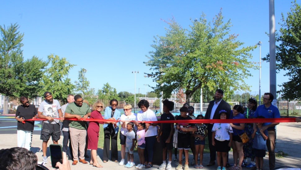 City officials and community members cutting ribbon at Piccoli Playground.