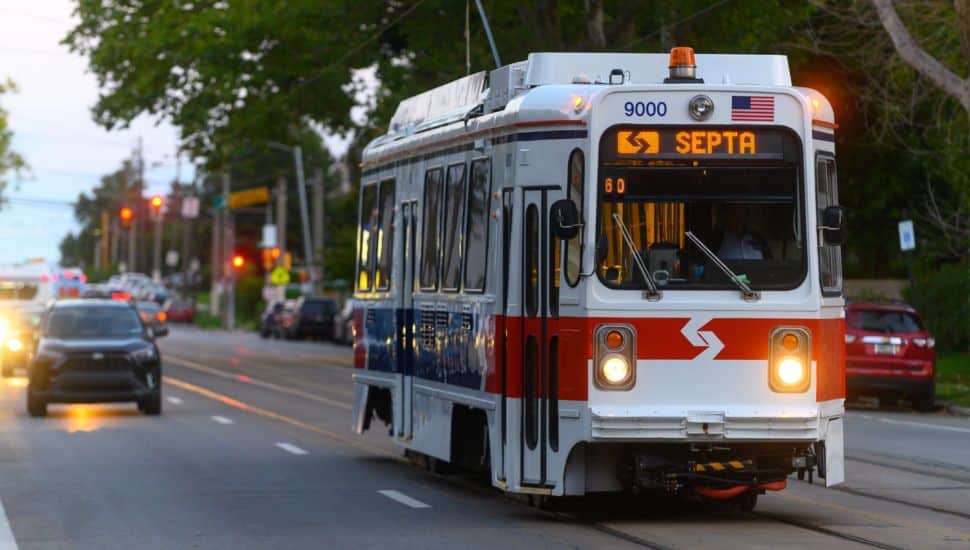 SEPTA Trolley with cars driving behind it.