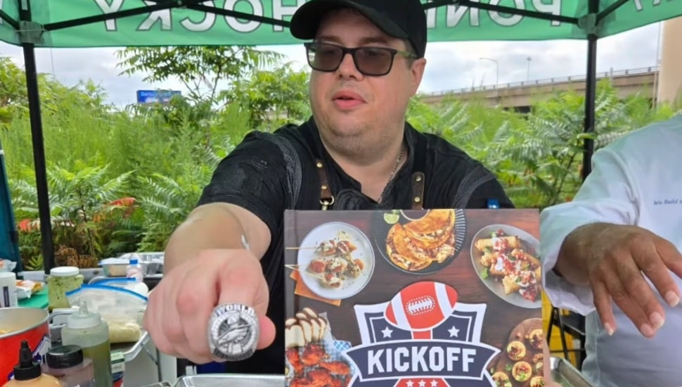 Tim Lopez vendoring while showcasing his Eagles Super Bowl ring and new cookbook.