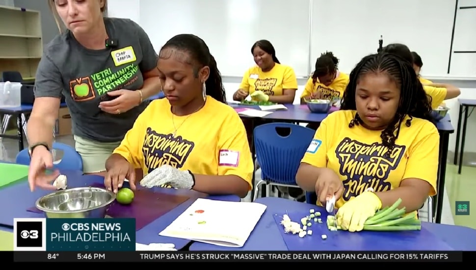 Students cooking and cutting vegetables.