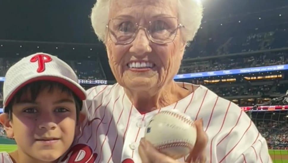 Donnay Moral holds the caught baseball at the Phillies game with Jameson Pennings.