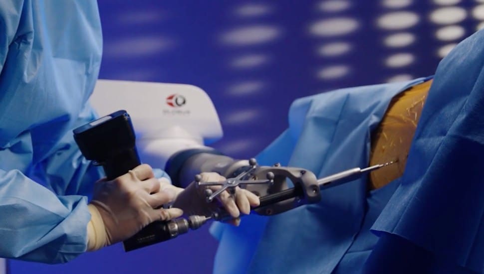 Surgeons using Globus Medical equipment for spinal surgery.