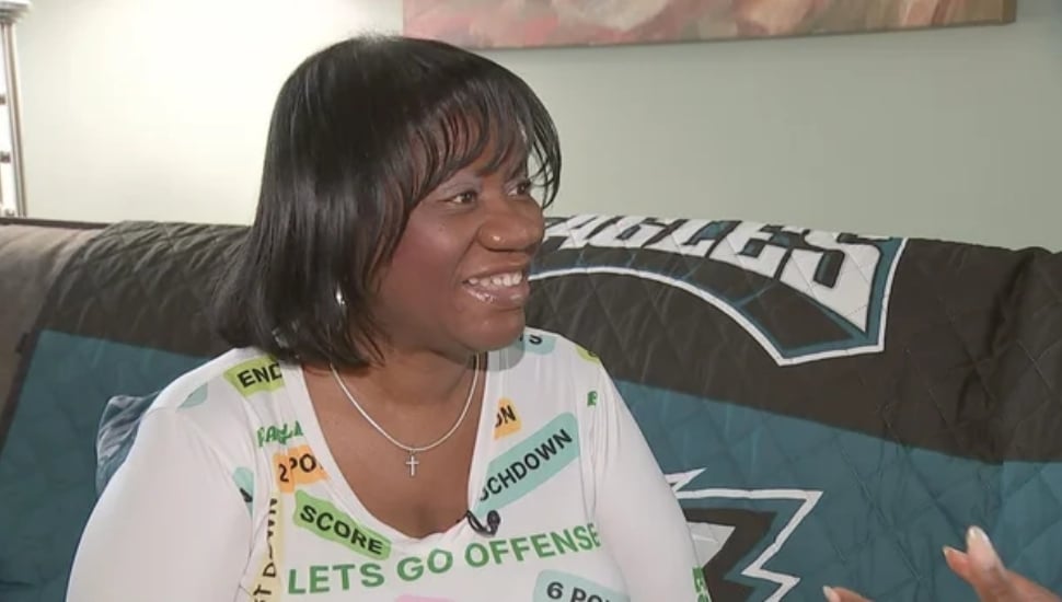 Shirley Ann Dash being interviewed while wearing Eagles gear.