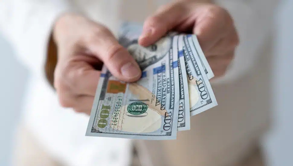 US dollars in hands of elderly woman.