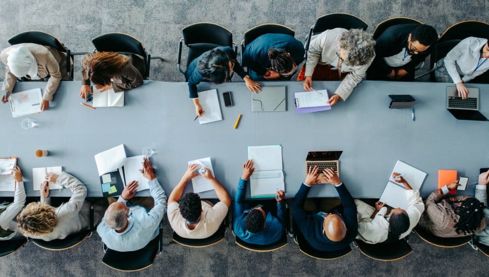 Top down view of people working at a table.