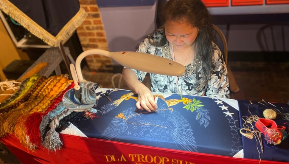A woman creating a flag.