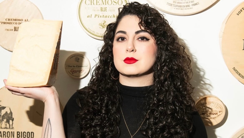 Emilia D'Albero holding a block of cheese.
