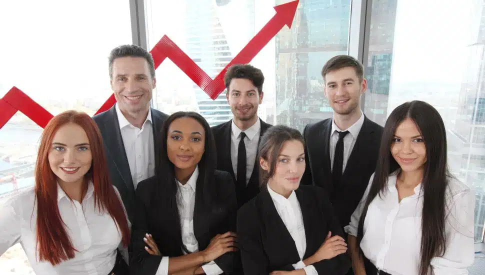 Portrait of business team of men and women in office with arrow graph of income growth