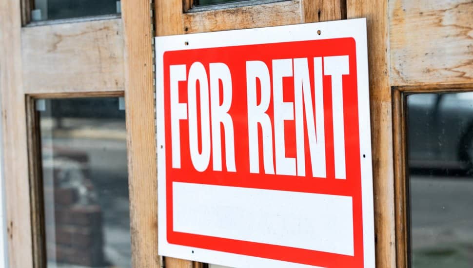 Apartment for Rent sign in a front yard.
