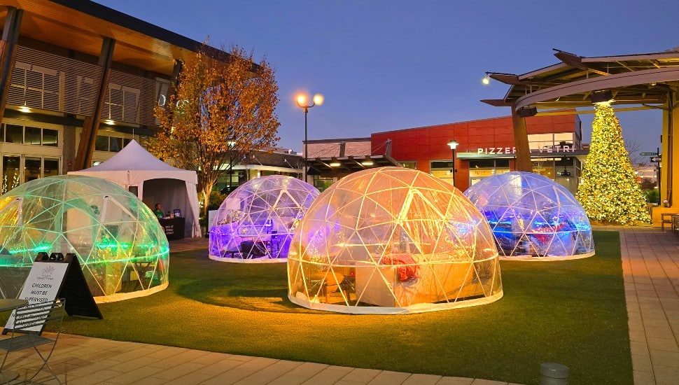 Plastic igloos for dining on green space in town center.