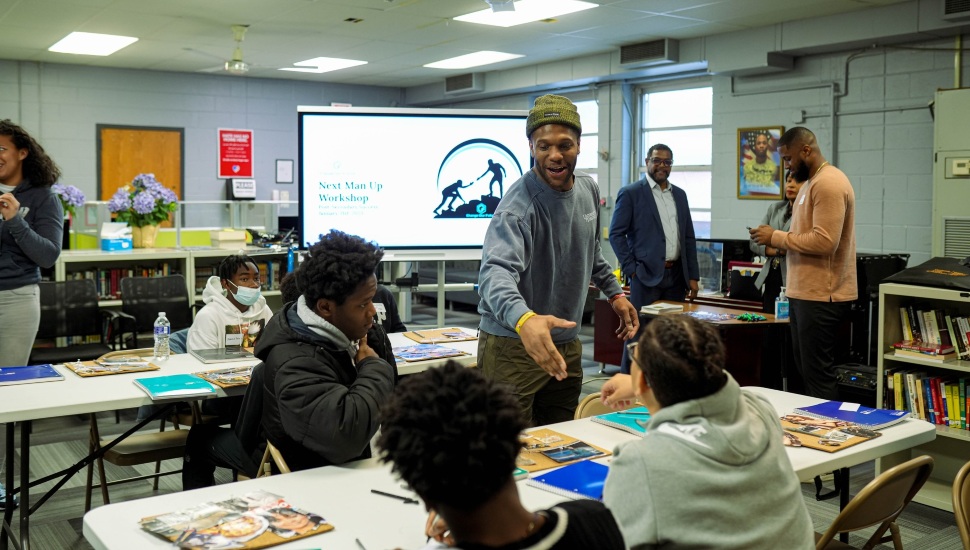 Rodney McLeod Jr. extending his hand out to a student.