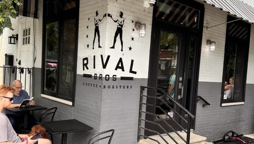 Rival Bros Coffee exterior with people sitting at the tables inside.
