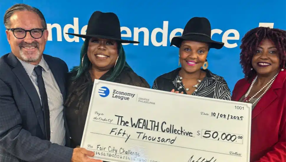 President of the Economy League of Greater Philadelphia and the founders of The WEALTH Collective holding $50,000 check.