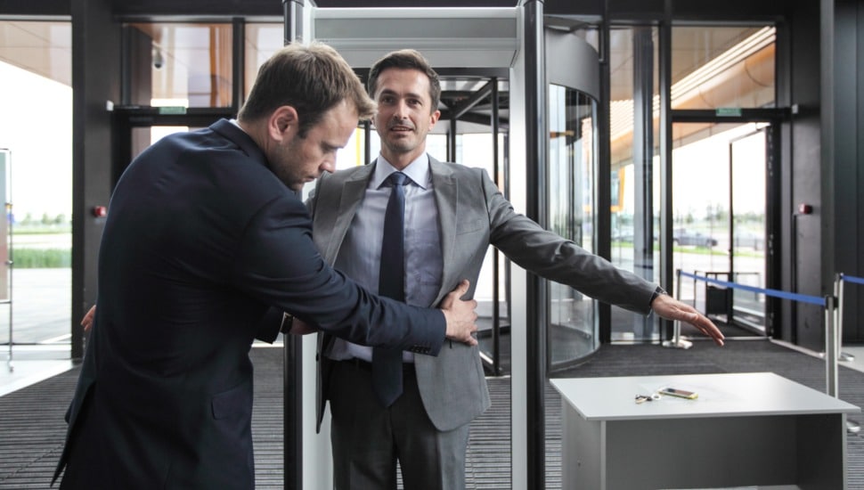 A businessman is frisked by airport security.