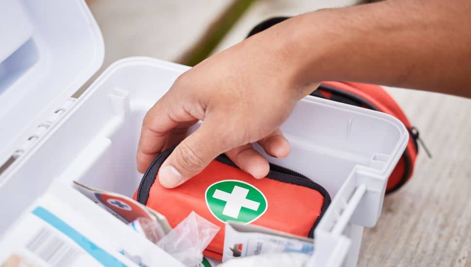 Person puling out first aid kit.