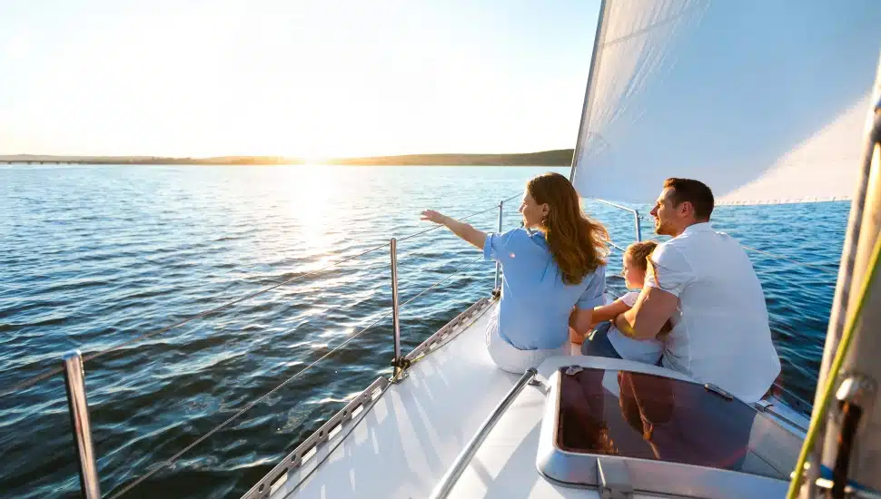 Family sitting on a yacht sailing across the sea