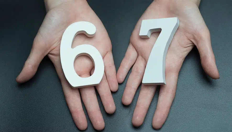 Female hands holding the numbers "6" and "7".
