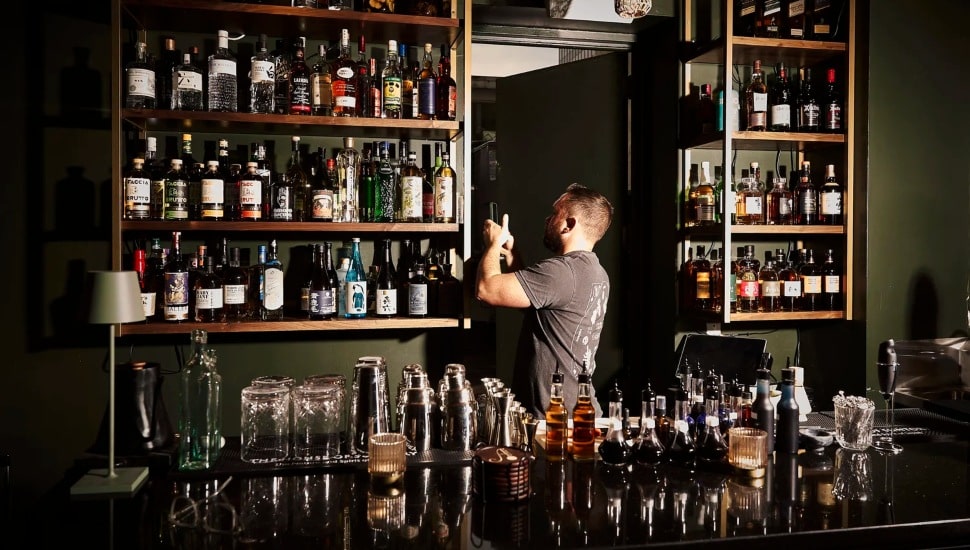 Danny Childs with countless bottles around him.
