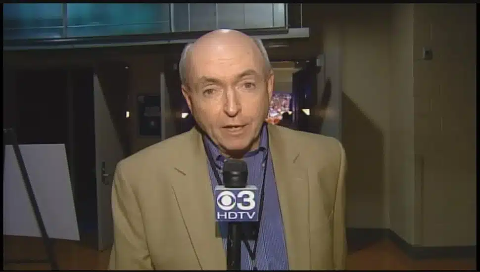 Harry Donahue reporting while holding a microphone.