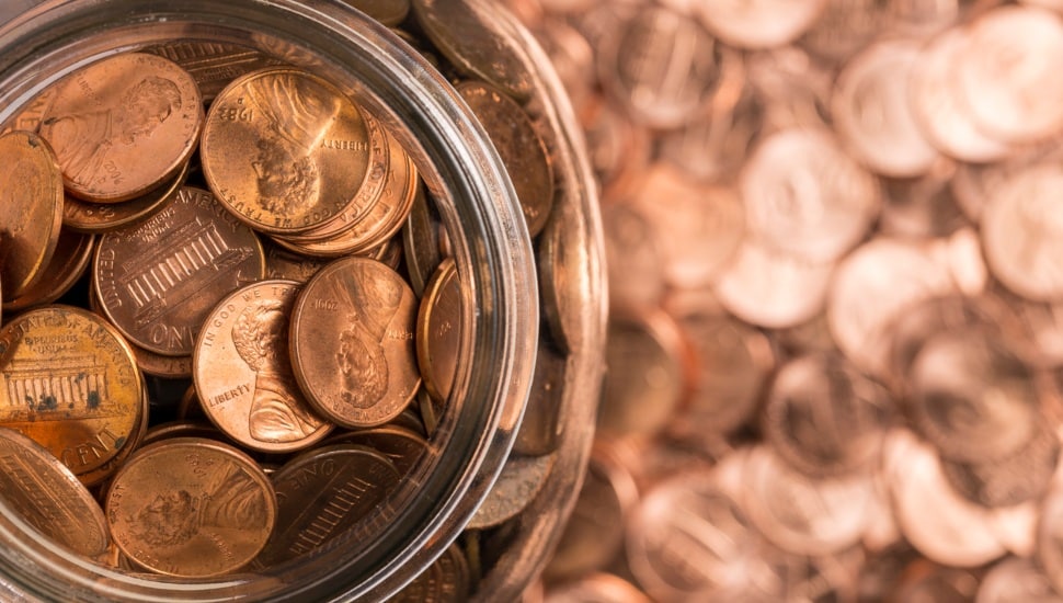 A jar of pennies surrounded by pennies.