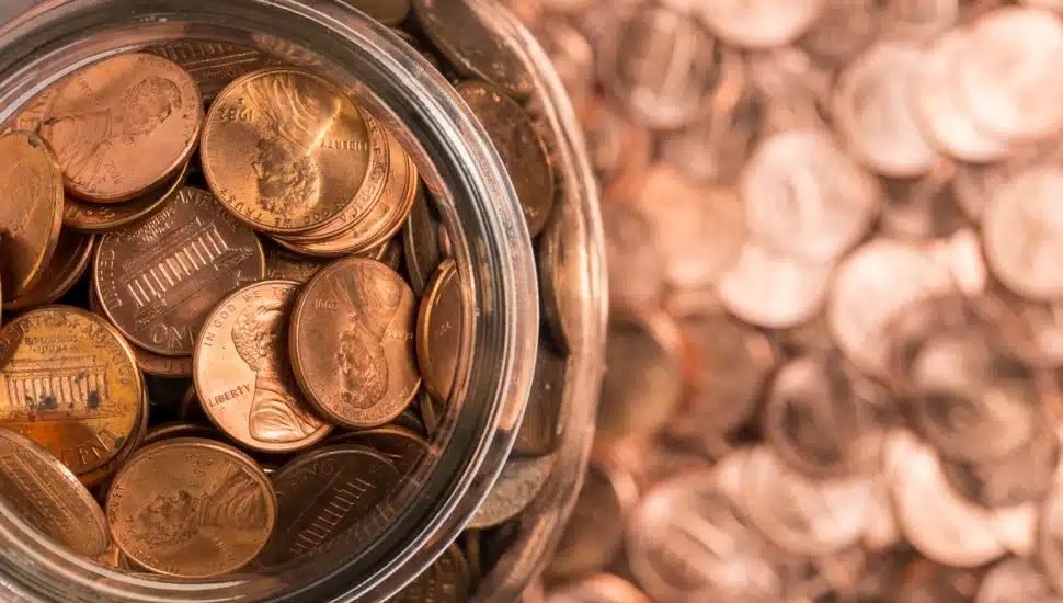 A jar of pennies surrounded by pennies.