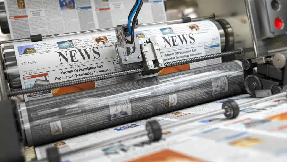 Newspaper and journals with news printing on a printing machine in a typography.