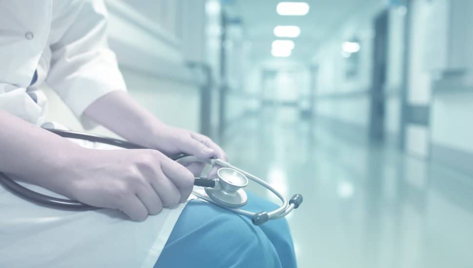 Doctor sitting in empty hallway.