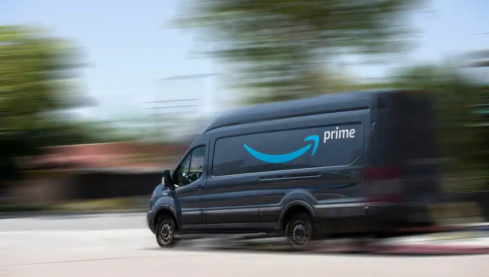 An Amazon delivery truck driving down a street.