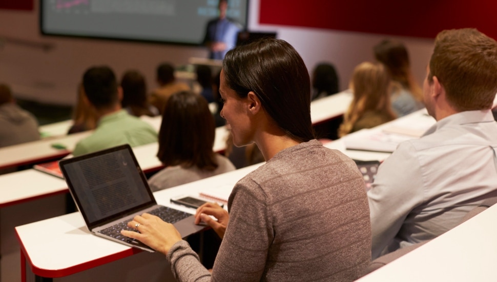 A college student using laptop during lecture