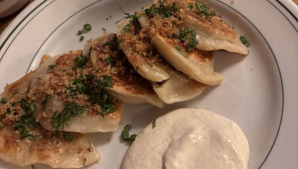 6 kapusta pierogis on a plate.