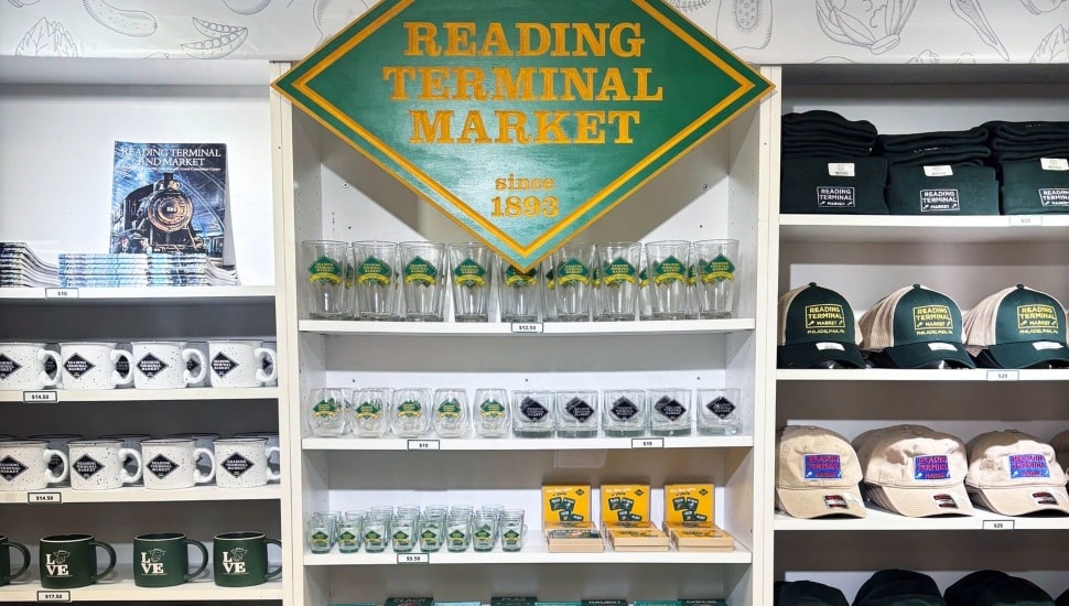 Inside Reading Terminal Market's new Market Merch store with mugs, glasses, hats, and sweatshirts.