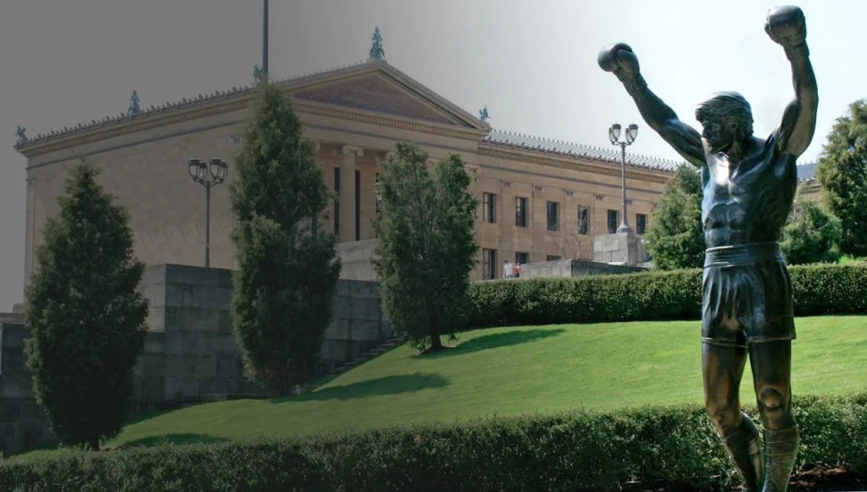 Rocky statue in the forefront with the Philadelphia Art Museum in the background.