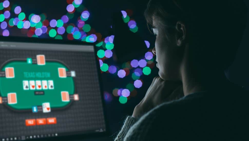 Woman playing online poker late at night, games and gambling concept.