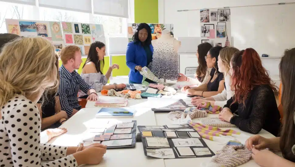 Jefferson University design students listening to their instructor in a room.