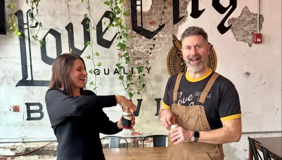 Love City Brewing owners Melissa and Kevin Walter opening a beer together.