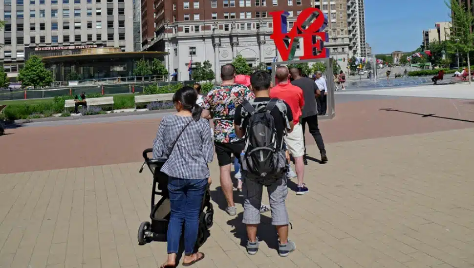 Tourists lining up to be photographed with Philadelphia's pop art LOVE sculpture.