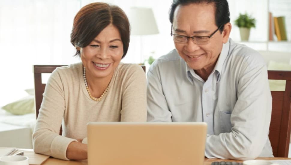 A couple looks at a laptop computer screen.